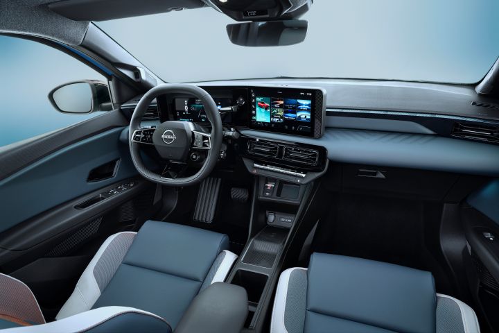 Passenger pov of full dashboard cockpit showing steering wheel, driver focused infotainment showing ECO drive mode, rear view mirror, front seats and side mirrors