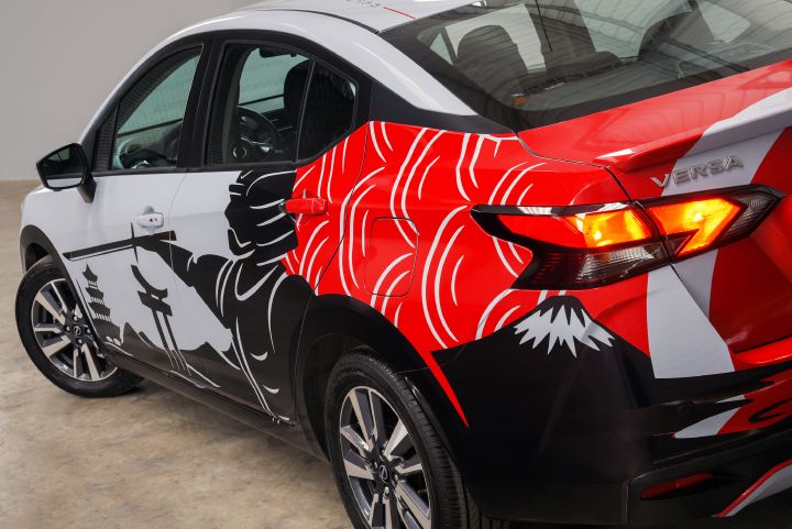 Detalhes do carro com pintura predominantemente branca e vermelha e elementos japoneses (vista traseira e lateral esquerda)