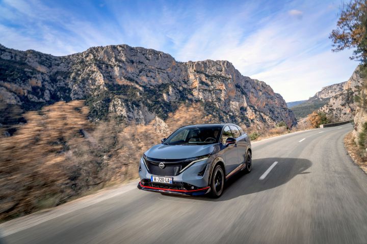 Dynamisch shot vanuit een ¾-hoek van de ARIYA NISMO op bergweg.