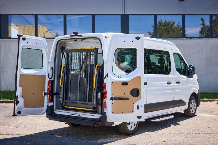 3/4-Heckansicht vom weißen Nissan Interstar-e mit MobiTEC Ausbau mit geöffneten Hecktüren und einem eingeklappten Rollstuhllift