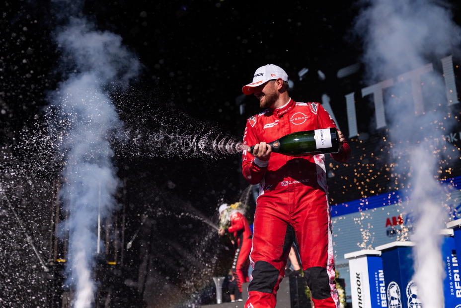 Landscape image of Nissan Formula E Team driver Oliver Rowland spraying champagne on the Berlin podium following his second placed finish
