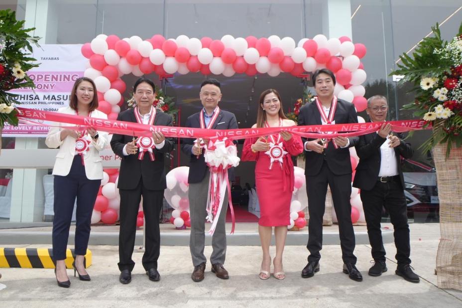 A group photo of Yasuhisa Masuda with the Management Team of Topcars Autoworld Corp. in front of the Nissan Tayabas- Quezon for the ribbon cutting.