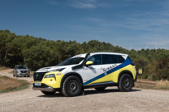Im Vordergrund steht der Nissan X‑Trail Rennwagens für die Baja Aragon Rallye 2024, im Hintergrund steht ein silberner, serienmäßiger Nissan X‑Trail