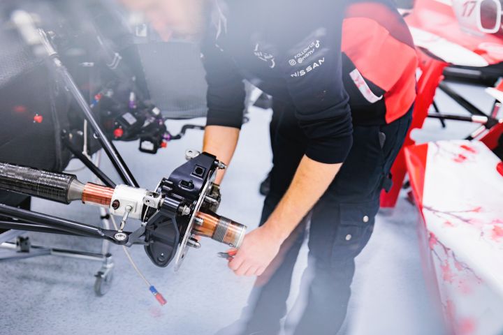 Nahaufnahme eines Mechanikers, der an der Radaufhängung des Nissan Formel E Rennwagens arbeitet