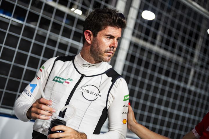 Norman Nato schaut vor einem E-Prix in seiner weißen Kühlweste zu einem Nissan Formel E Teammitglied neben ihm, das ihn am Arm berührt.