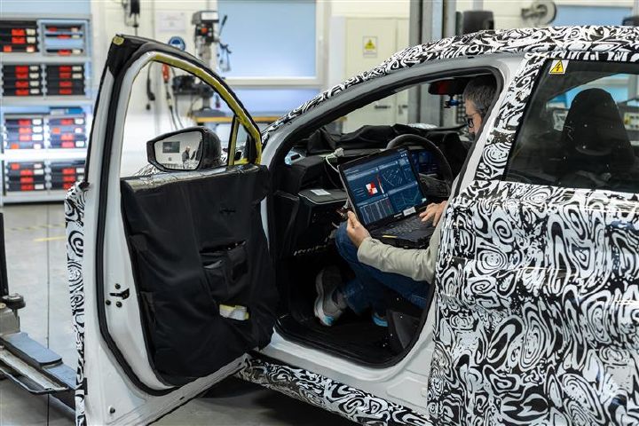 A Nissan engineer seated in a test vehicle working on a laptop using Monolith AI software.