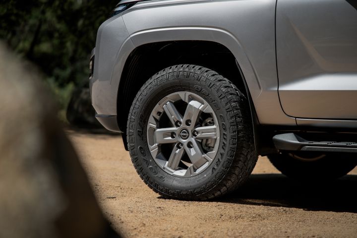 2026 Nissan Navara ST dual cab ute finished in Summit Silver featuring a close-up of the front alloy wheel, tyre tread, side step and wheel-arch trim.