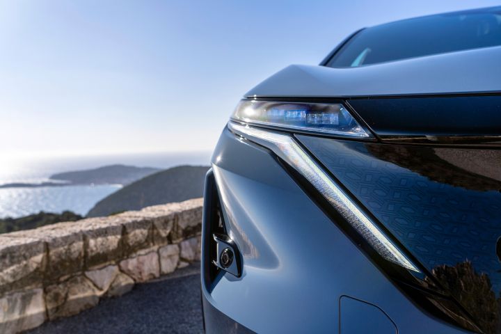 Gros plan sur un phare d'une Nissan Ariya NISMO gris-bleu