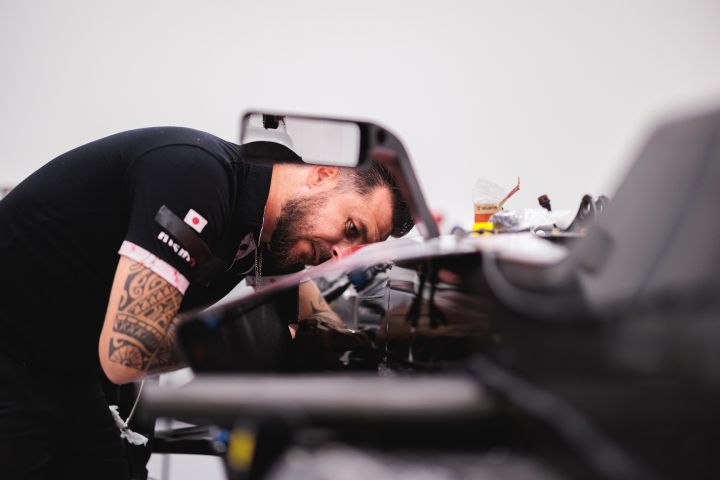 An einem Nissan Formel E Rennwagen nimmt ein Mechaniker Einstellungen vor