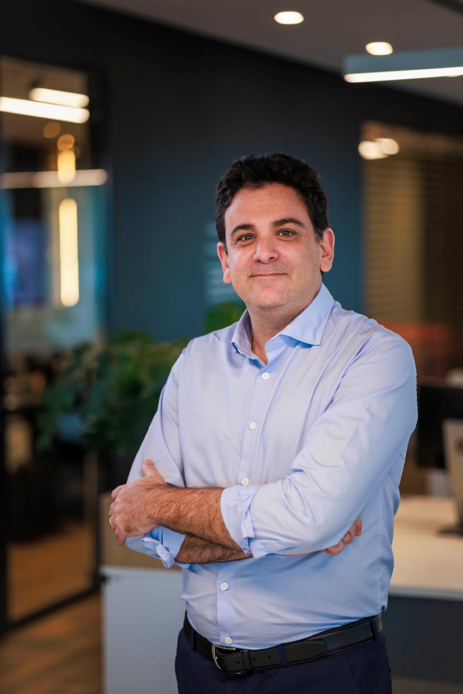 Nicolas Abbate, Director de Asuntos Externos, Gubernamentales y Sustentabilidad Nissan América Latina en las oficinas con una camisa azul cruzado de brazos.