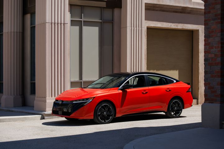 Angled profile view of the 2026 Nissan Sentra parked in front of a city building.