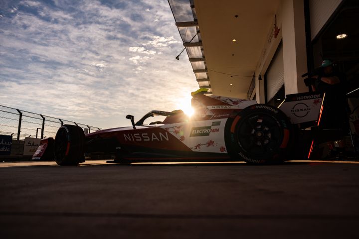 Seitenaufnahme des Nissan e‑4ORCE 05 in der Boxengasse mit der aufgehenden Sonne im Hintergrund kurz vor Beginn des freien Trainings in Miami.