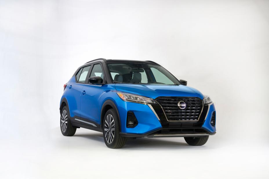 The front right view of a blue 2021 Nissan Kicks in a white showroom setting