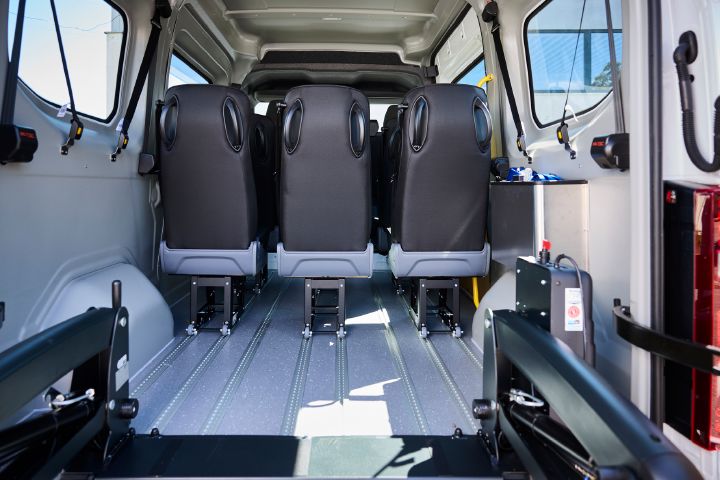 Blick auf die Rückseite der auf Schienen nach vorne geschobenen Sitze der dritten Sitzreihe im Nissan Interstar-e mit MobiTEC Ausbau