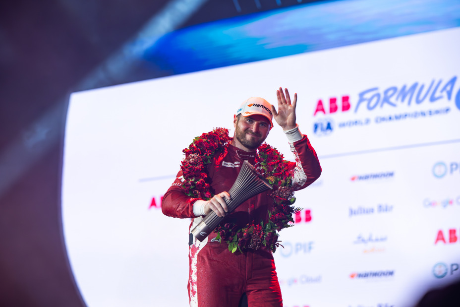 Oliver Rowland com equipamento da Nissan Formula E Team com troféu na mão direita a dizer adeus