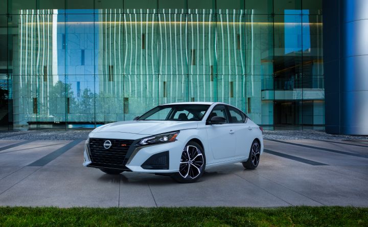 Front left view of the 2023 Nissan Altima parked in front of a building.