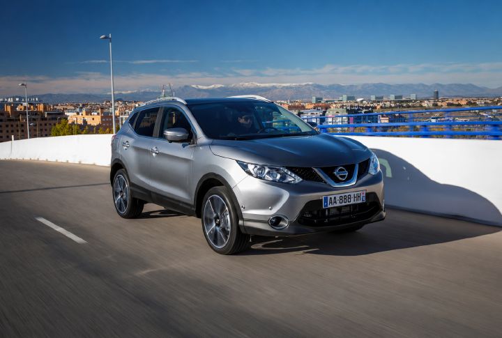 A second generation Qashqai driving past a city