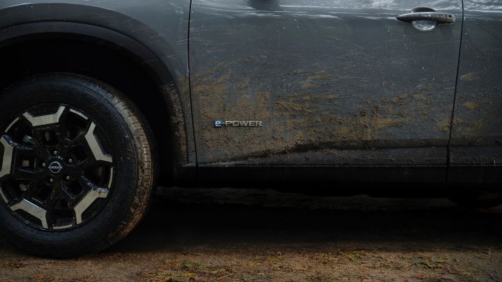 Detailansicht der schlammbespritzten Flanke des grauen Nissan X‑Trail N-Trek