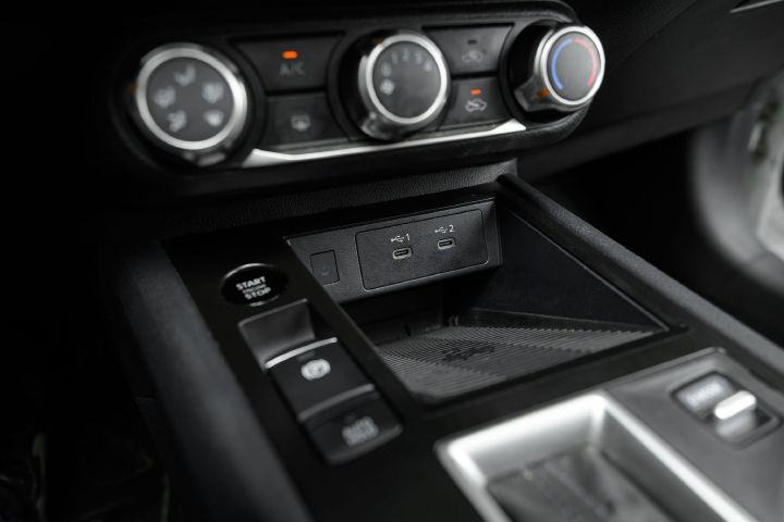 Close up of the center console controls, charger ports and wireless charger inside the 2026 Nissan Kicks.