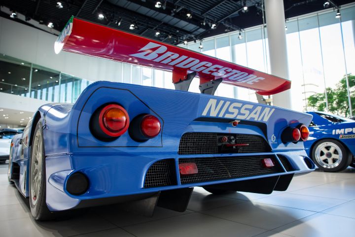 A view of the rear of a blue Nissan R390 GT1 Le Mans race car with large red-colored rear spoiler shown.