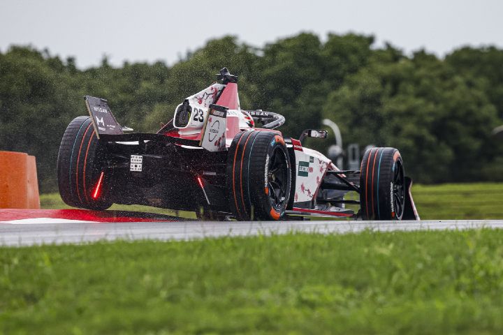 Rückansicht von Norman Nato auf der Rennstrecke im Nissan Formel E Rennwagen mit der Startnummer 23, wie er über einen Randstein fährt.