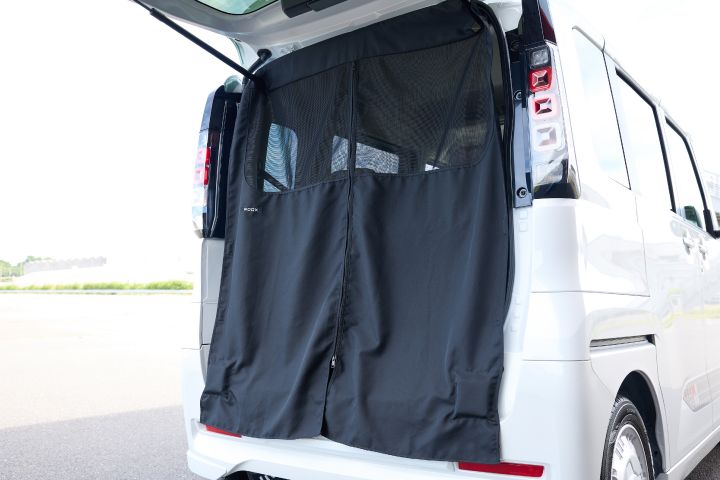 A black luggage net is installed in the rear space of the new Nissan Roox kei car. This accessory helps secure and organize items, enhancing interior tidiness and utility.
