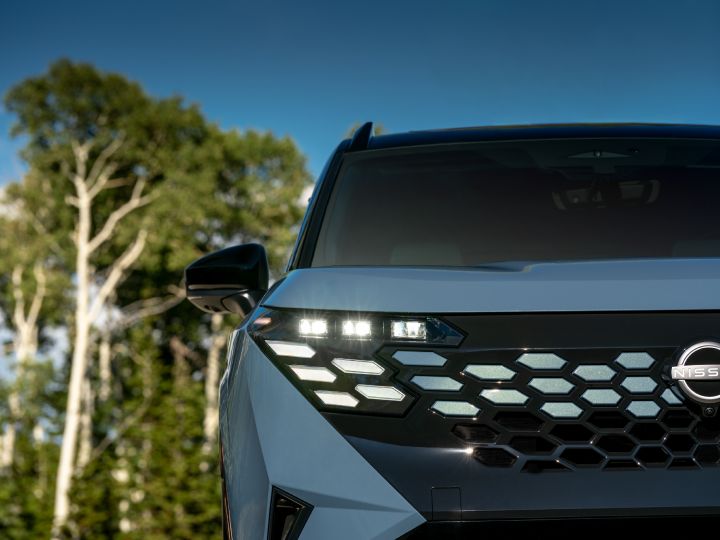 グロスブラックのグリルとボディ同色のアクセントを組み合わせた新型日産ローグ ハイブリッド プラチナム。フロントフェイスに奥行きと上質な存在感をもたらしている。