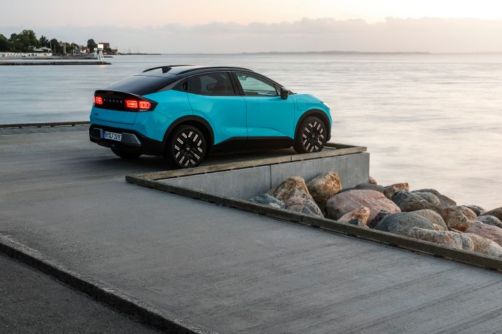 3/4 Heckansicht eines türkisen Nissan LEAF, der auf einem Kai mit Blick aufs Meer parkt