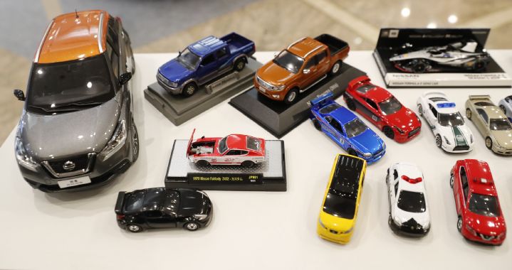 Miniaturas de carros da Nissan com um Kicks cinza e laranja no lado esquerdo e outros modelos ao lado
