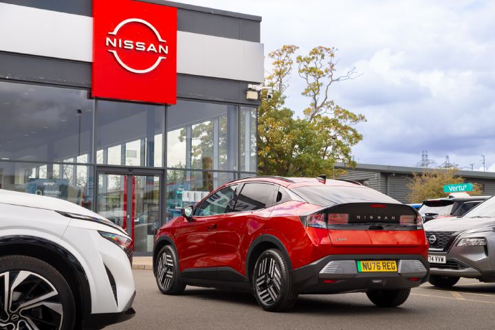 Rear view of a red Nissan LEAF outside a Nissan showroom