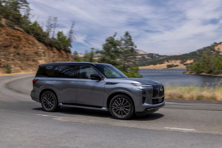 湖を背に角を曲がるダークグレーのINFINITI QX80 SUV