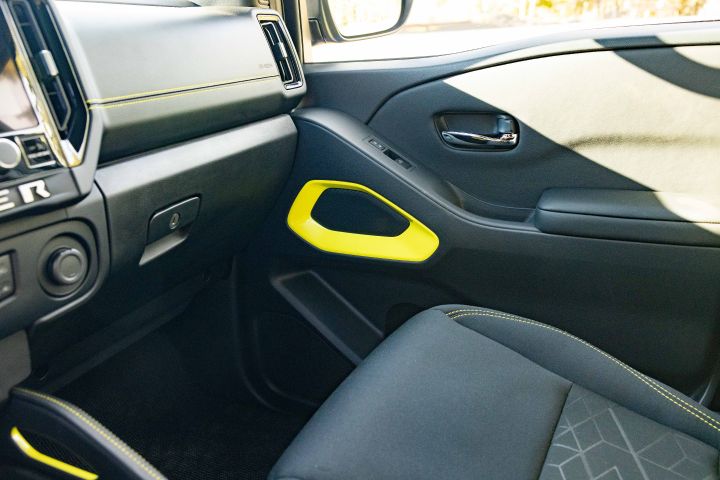 Close up of the gear shift and yellow interior details inside the 2027 Nissan Frontier Sport Edition.