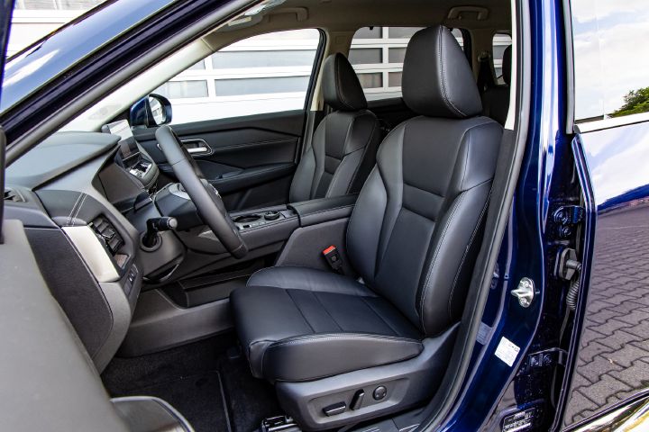 Blick durch die geöffnete Fahrertür auf die beiden vorderen Sitze im Innenraum des Nissan X‑Trail
