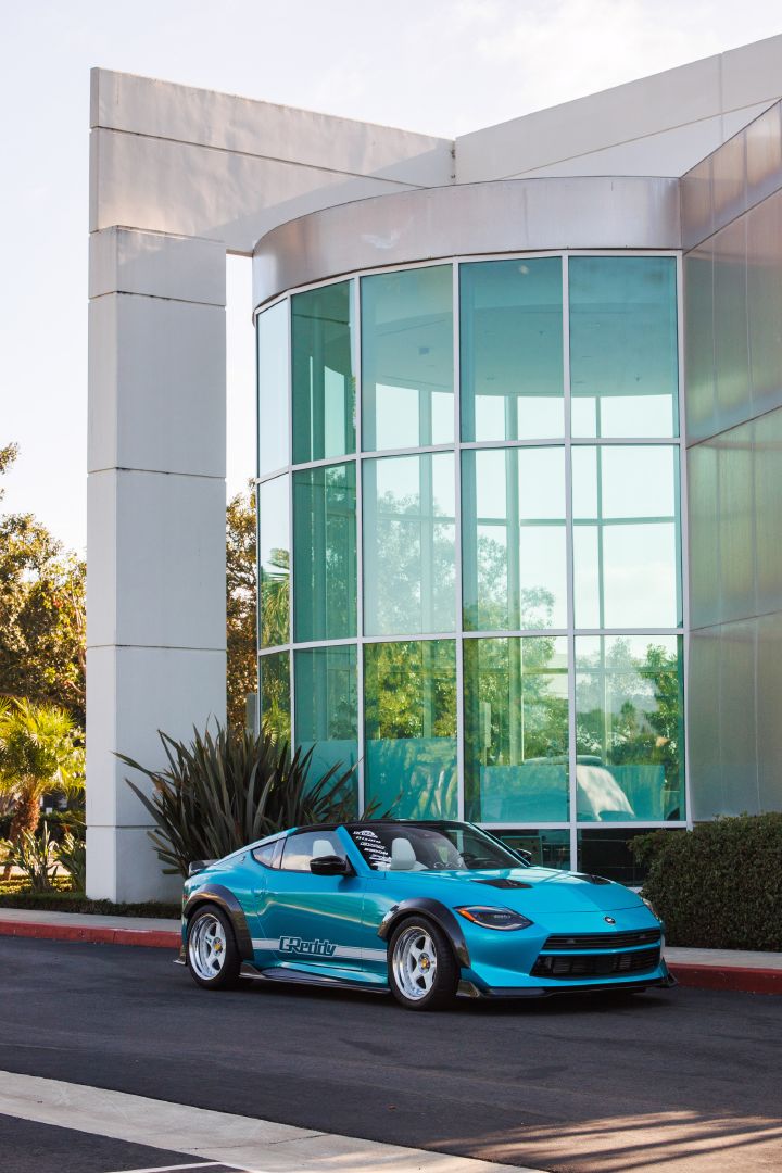 Front right 3/4 view of the Nissan Z Kaze Concept parked in front of a glass building.