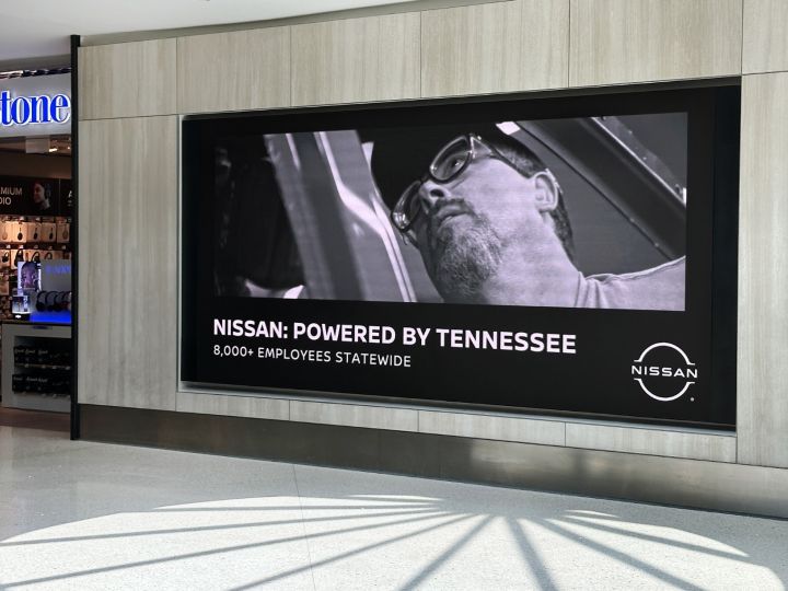 A "Nissan: Powered by Tennessee" banner hanging on a wall with a workers face as the main image.