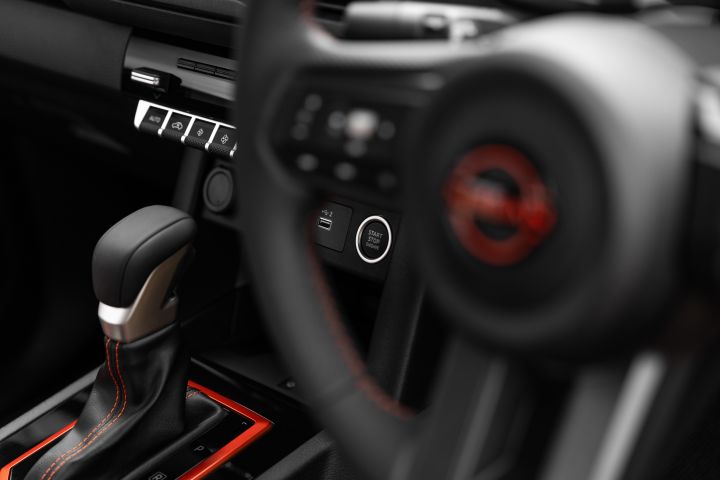 2026 Nissan Navara PRO-4X finished in Boulder Grey spotlighting the engine start button, USB ports, switchgear, gear lever and blurred steering wheel rim.