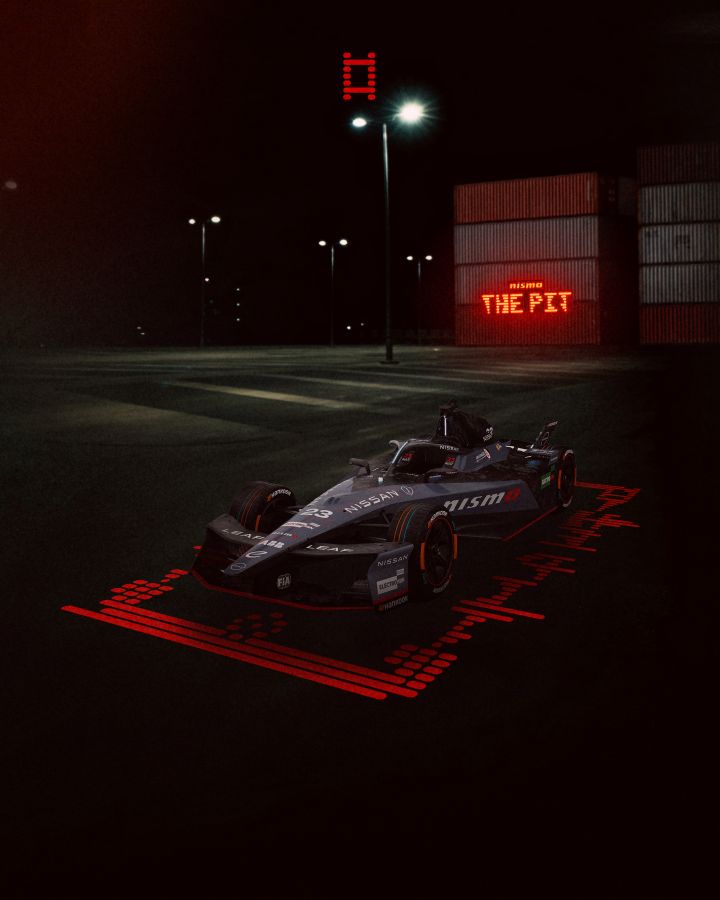 Porträtansicht von vorne und von der Seite des Nissan e‑4ORCE 05 mit der Startnummer 23 und der einzigartigen, einmaligen NISMO-Lackierung, im Hintergrund ist das „The NISMO Pit“-Logo zu sehen.