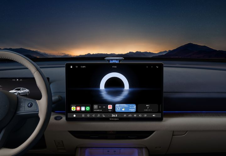 The Teana’s dashboard with a large central touchscreen displaying navigation and vehicle information. The background shows a night view with mountains and a starry sky.
