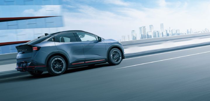 Image dynamique – vue latérale de la LEAF NISMO avec en fond des immeubles