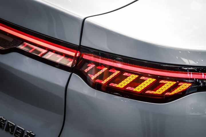 東風日産の白い新型セダン電気自動車「N7」のテールランプのクローズアップ。赤とオレンジのパターンが点灯。
