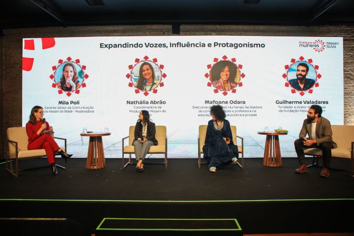 Painel de discussão com Mila Poli, Nathália Abrão, Mafoane Odara e Guilherme Valadares. Ao fundo, um telão com o título "Expandindo Vozes, Influência e Protagonismo".