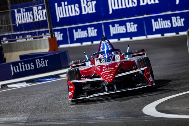 Monolugar vermelho da Nissan Formula E Team visto de frente, em pista, com placard em azul atrás