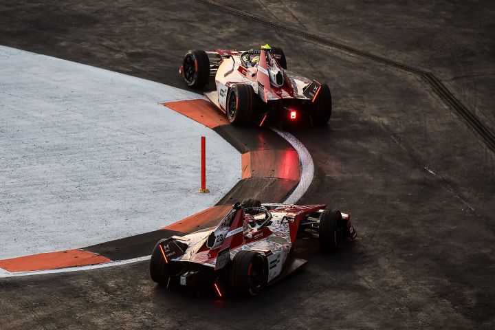 Beide Fahrzeuge des Nissan Formel-E-Teams fahren eine Linkskurve.