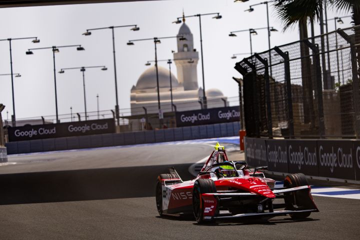Frontalaufnahme von Oliver Rowland auf der Rennstrecke im Nissan e‑4ORCE 05 mit der Startnummer 1 während des E-Prix-Wochenendes in Dschidda, im Hintergrund ragt ein Gebäude auf.