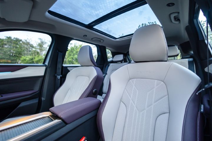 Front passenger area with perforated seats, panoramic glass roof and interior finishes.