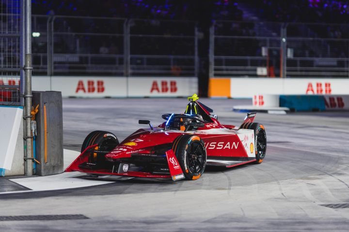 La voiture de course Nissan Formule E dévale la piste de course la nuit.