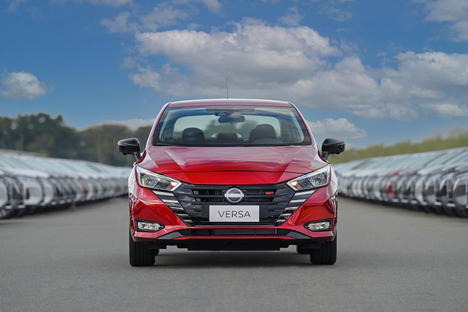 Nissan Versa SR vermelho estacionado entre fileiras de carros estacionados