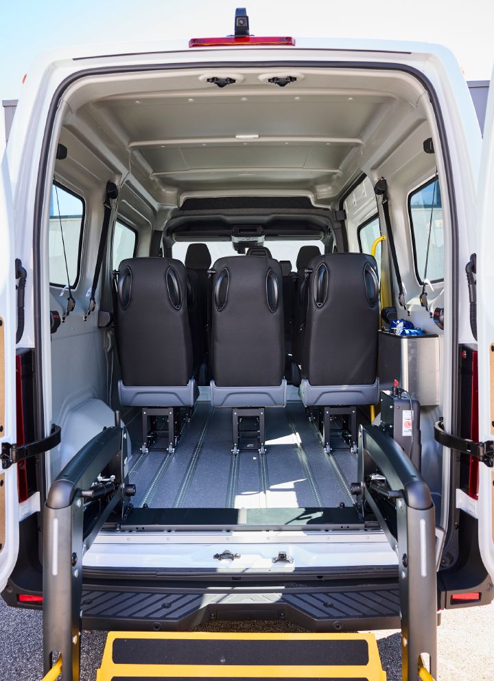 Blick durch die geöffneten Hecktüren ins Innere des Nissan Interstar-e mit MobiTEC Ausbau mit sechs auf Schienen verschiebbaren Einzelsitzen