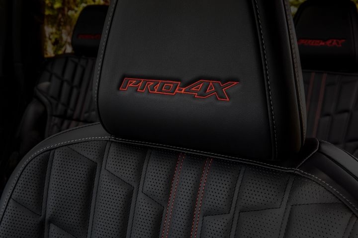 Close up of the 2025 Nissan Armada Pro4X black leather seat with Pro4x is stitched in red on the headrest.