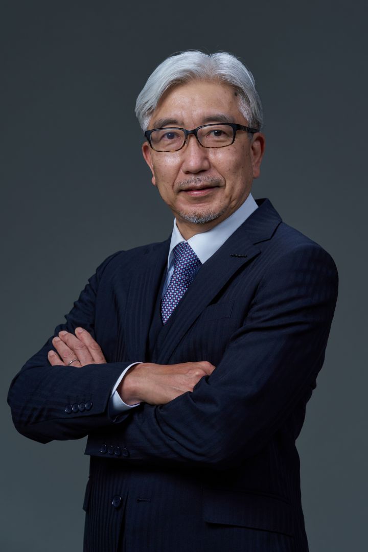 Portrait of Mitsuro Antoku with navy suit, navy-white dot tie and NISSAN corporate pin with his arms folded